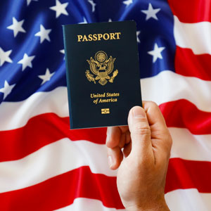Person holding American passport with flag on background- Serving Immigrants
